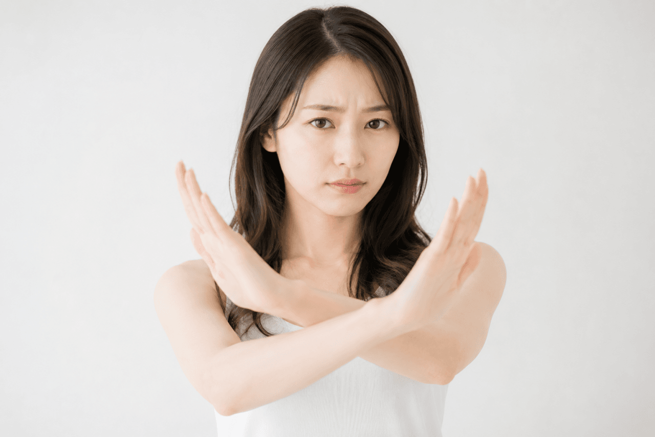 だめというジェスチャーをしている若い女性